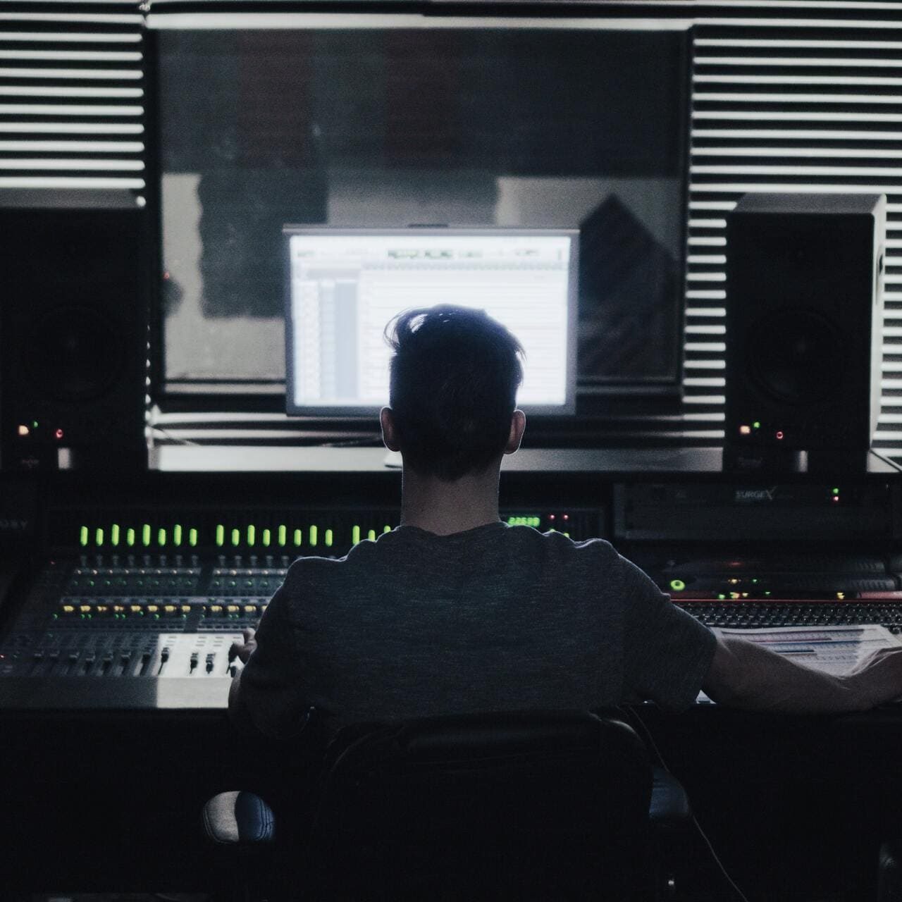 tom-pottiger-l5XnUP7-M4w-unsplash homme qui est devant une régie son 128